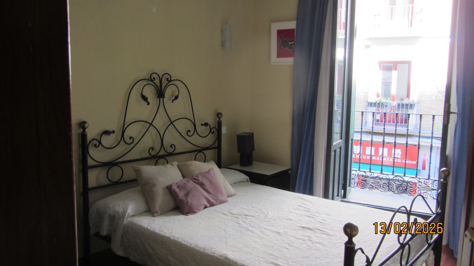 Dormitorio principal con cama de matrimonio y balcón a Calle de los Reyes