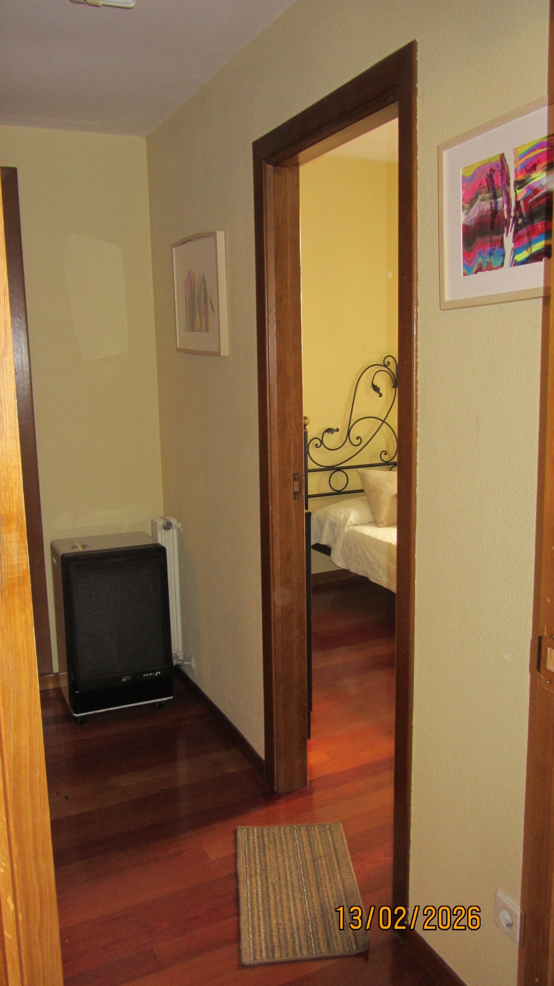 Pasillo en L de acceso a la habitación, con armarios empotrados a los lados y baño al fondo
