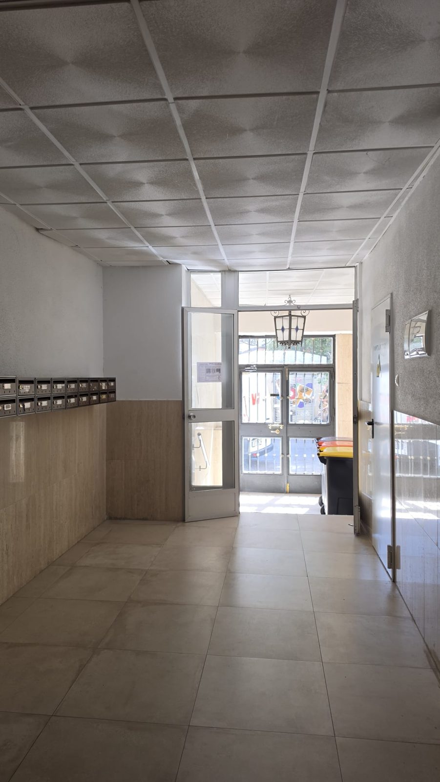 Portal del edificio de Calle Cartagena con buzones y acceso acristalado a la calle